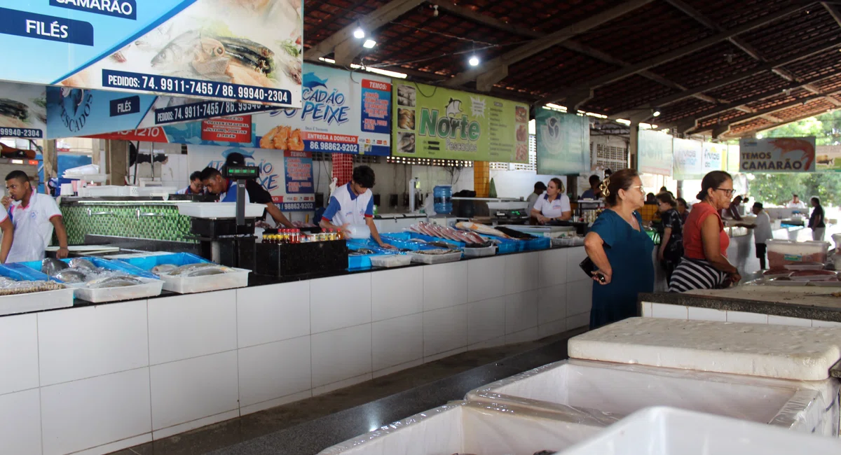 Clientes consultam preços no Mercado do Peixe