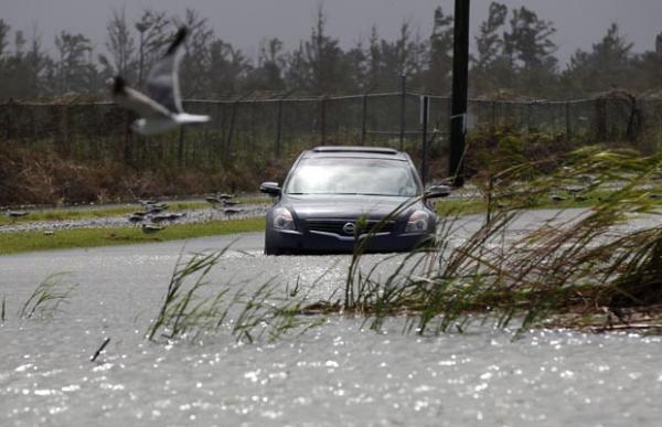 Carro passa em área de Venice, Louisiana, já alagada nesta terça-feira (28) por chuva associadas a Isaac (Imagem:Reprodução)